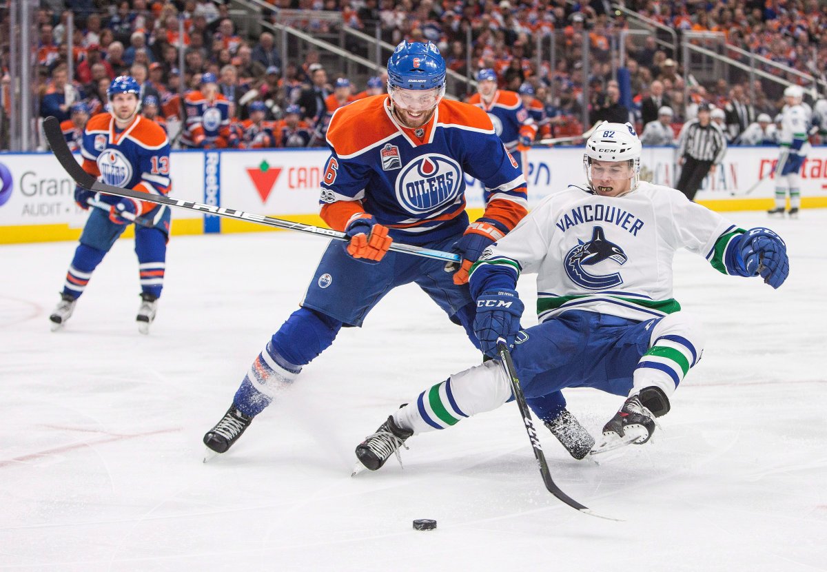 Vancouver Canucks' Nikolay Goldobin (82) falls as Edmonton Oilers' Adam Larsson (6) defends during third period NHL hockey action in Edmonton, Alta., on Sunday April 9, 2017. THE CANADIAN PRESS/Amber Bracken.