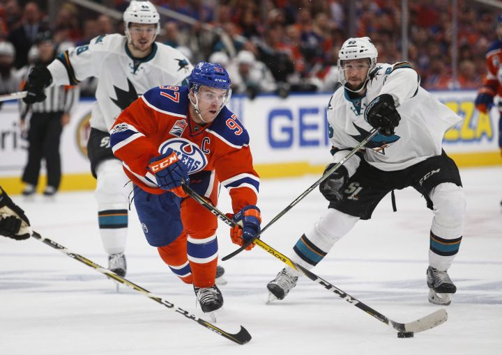 San Jose Sharks' Melker Karlsson, right, of Sweden, looks on as Edmonton Oilers' Connor McDavid gets away from him during overtime NHL hockey round one playoff action in Edmonton, Thursday, April 20, 2017. 