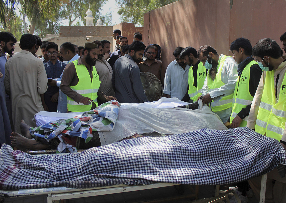 Pakistani volunteers and local residents gather around the bodies of people who were killed in a local shrine, outside the morgue of a hospital in Sarghodha, Pakistan, Sunday, April 2, 2017. 