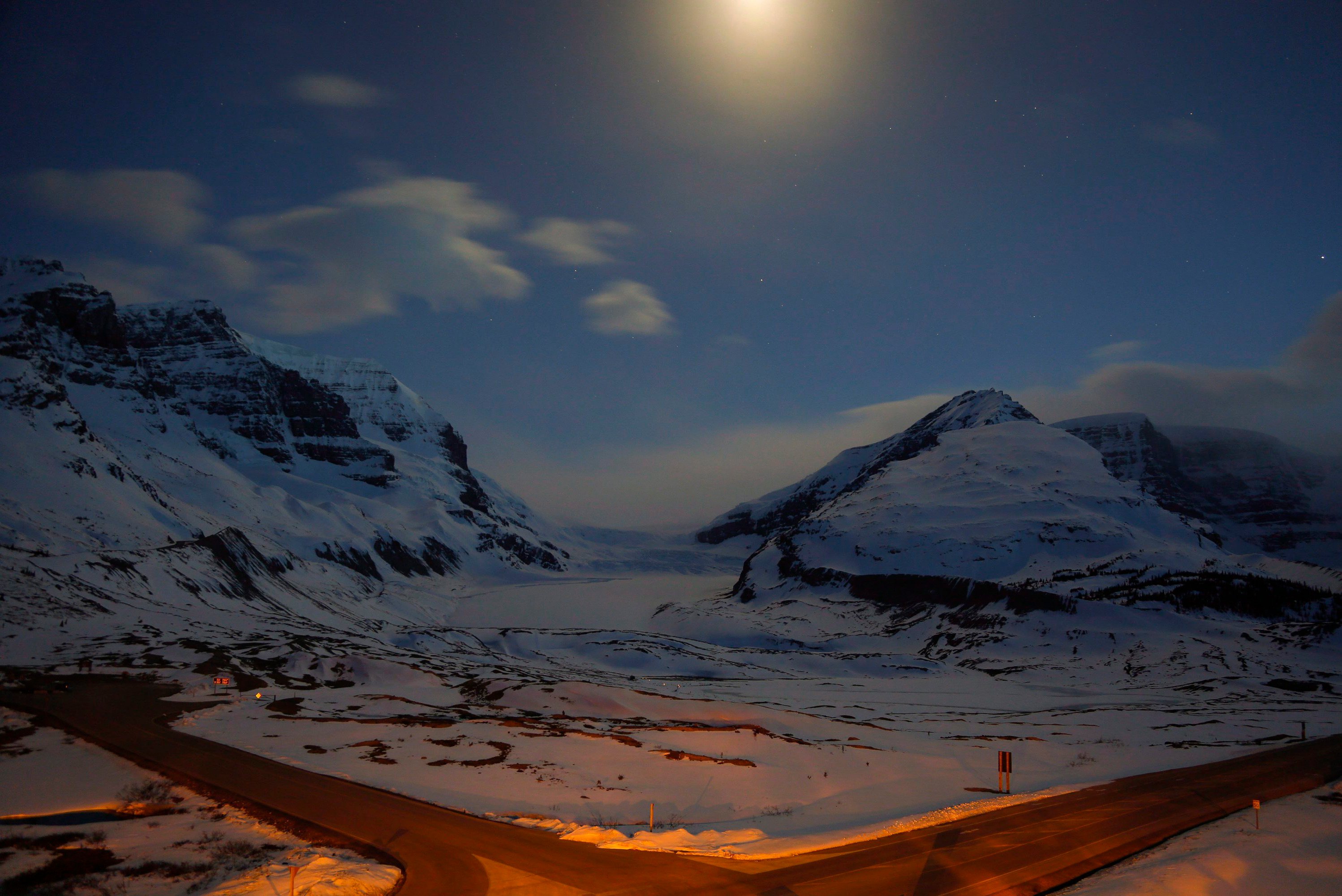The Athabasca Glacier, centre, part of the Columbia Icefields in Jasper National Park, Alta., is seen in moonlight during a long exposure Wednesday, May 7, 2014. Parks Canada often promotes the Icefields Parkway between Jasper and Banff as "one of the most scenic drives in the world," but a plan to build a bike path along the route has hit its fair share of bumps in the road. 