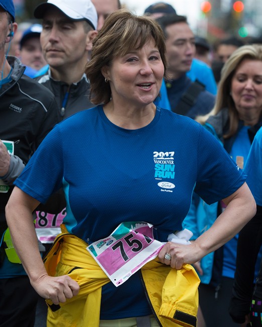 Liberal Leader Christy Clark ties her jacket around her waist as she jogs to the start line to participate in the Sun Run, in Vancouver, B.C., on Sunday April 23, 2017. A provincial election will be held on May 9.