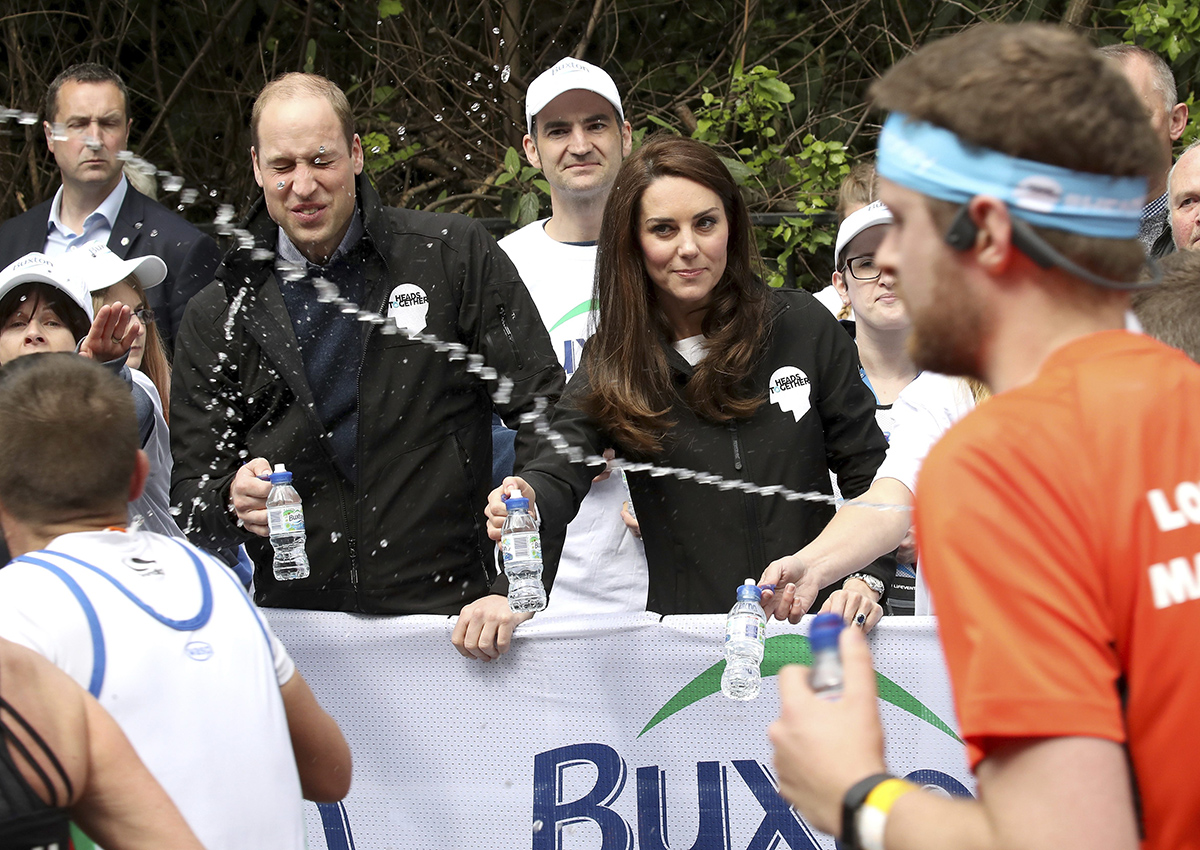 A runner squirts water towards Britain's Prince William, the Duke of Cambridge, as he hands out water to runners during the London Marathon in London, Sunday, April 23, 2017. 