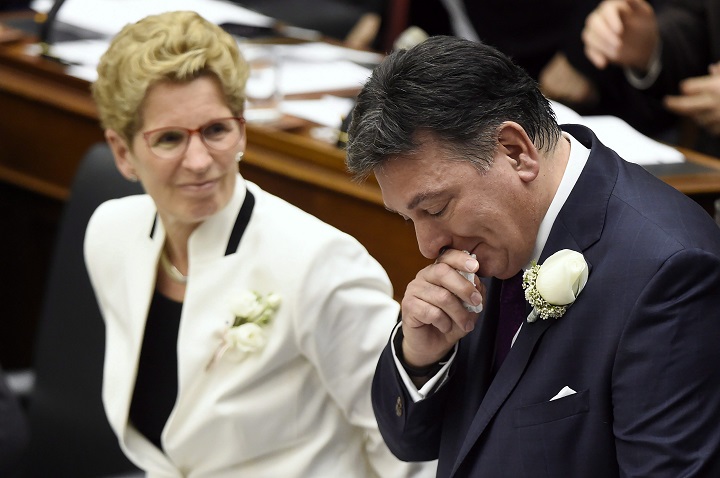 Ontario Finance Minister Charles Sousa, right, cries as he delivers the 2017 Ontario budget next to Premier Kathleen Wynne at Queen's Park in Toronto on Thursday, April 27, 2017. 