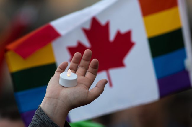 A person holds a candle during "Kingston stands in Solidarity with Orlando" in Kingston, Ont., on June 13, 2016. 