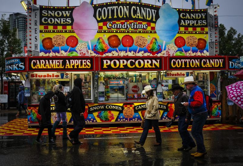 Visitors pass by a food stall at the Calgary Stampede in Calgary, Alta., Sunday, July 17, 2016.