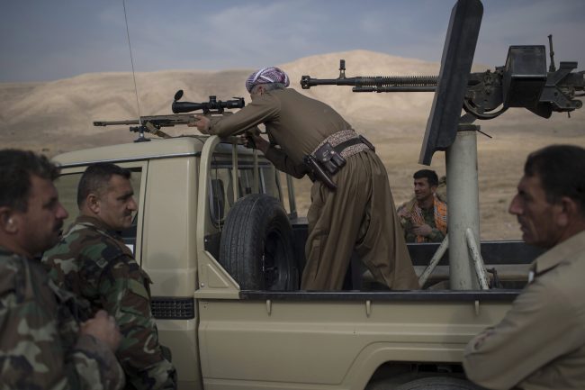 A Kurdish Peshmerga fighter looks at Islamic State militant positions during heavy fighting in Bashiqa, east of Mosul, Iraq, Tuesday, Nov. 8, 2016. 