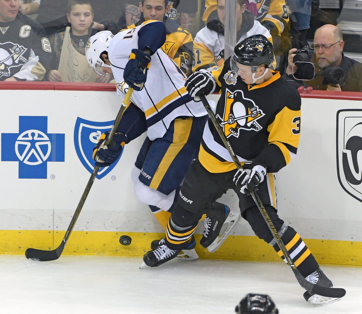 Nashville Predators right wing Craig Smith (15) and Pittsburgh Penguins defenceman Olli Maatta (3) vie for a loose puck during the first period of an NHL game. 
