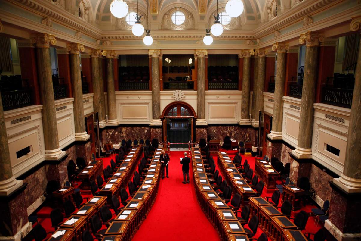 Chamber staff put the orders of the day on the desk of cabinet members before the B.C. Finance Minister Michael de Jong delivers the budget at the Legislative Assembly in Victoria, B.C. on Feb. 21, 2017.