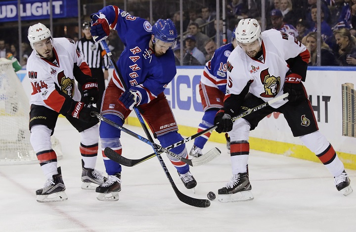 New York Rangers' Kevin Hayes (13) fights for control of the puck with Ottawa Senators' Jean-Gabriel Pageau (44) and Cody Ceci (5) during the second period of Game 6 of an NHL hockey Stanley Cup second-round playoff series, Tuesday, May 9, 2017, in New York.