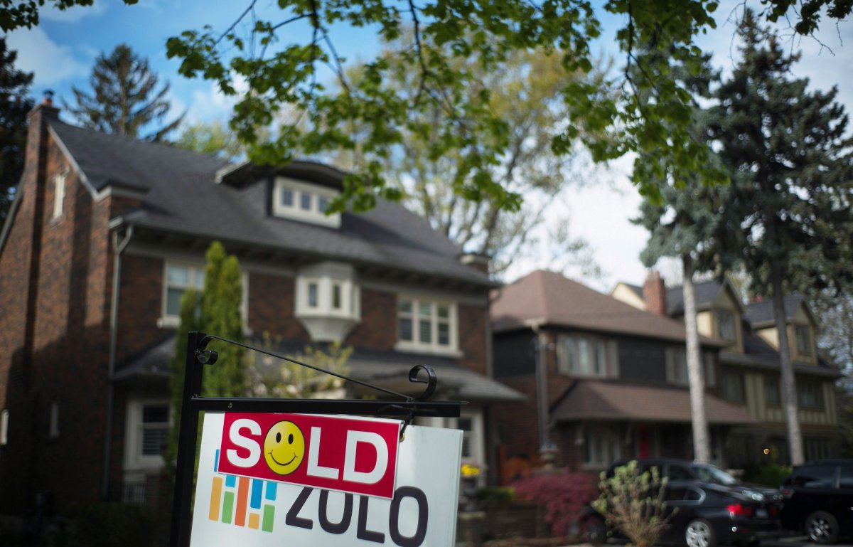 A sold sign is shown in front of west-end Toronto homes, Sunday, May 14, 2017. Home sales cooled in April after setting a record the previous month as the pace of transactions in the Greater Toronto Area slowed, the Canadian Real Estate Association said Monday.