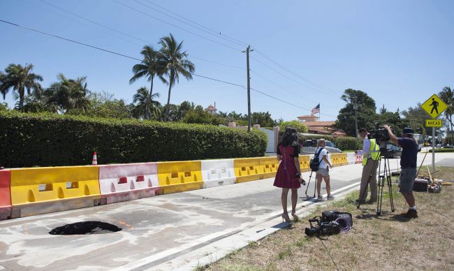 A TV crew reports next to a recently opened sinkhole near President Donald Trump's Mar-a-Lago estate, Monday, May 22, 2017 in Palm Beach, Fla. 
