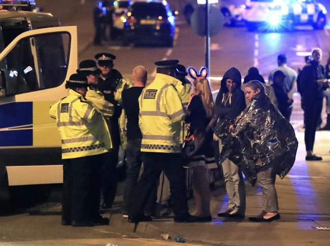 Emergency services personnel speak to people outside Manchester Arena after the reported explosion, May 22, 2017. 