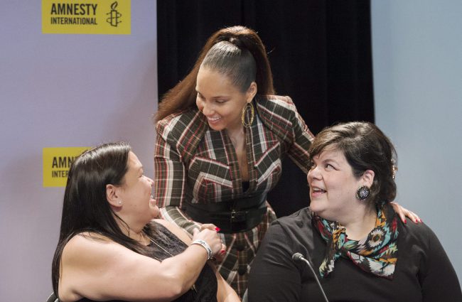 Alicia Keys, centre, greets Indigenous rights activists Melanie Morrison, left, and Melissa Mollen Dupuis in Montreal, May 27, 2017. 