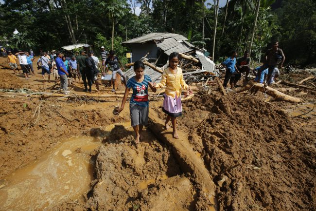 Children walk in mud where a landslide occured in at Athwelthote in Baduraliya, some 98 kilometers from Colombo, Sri Lanka, 28 May 2017. 