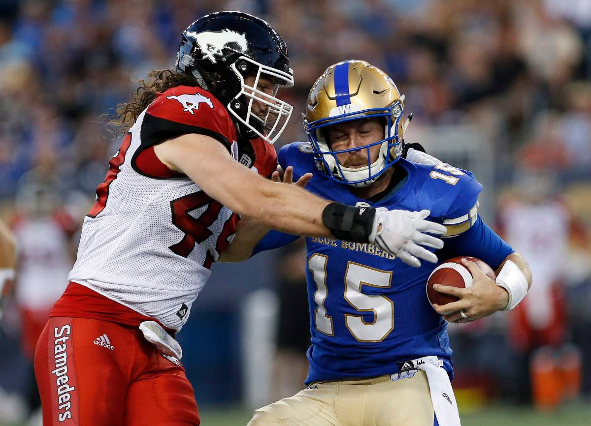 Calgary Stampeders' Alex Singleton (49) stops Winnipeg Blue Bombers quarterback Matt Nichols (15) during the second half of CFL action in Winnipeg Friday, July 7, 2017. THE CANADIAN PRESS/John Woods.
