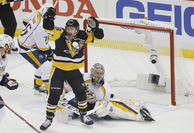 Pittsburgh Penguins' Jake Guentzel, front, celebrates a goal by teammate Evgeni Malkin in front of Nashville Predators goalie Pekka Rinne during the first period in Game 1 of the NHL hockey Stanley Cup Final, Monday, May 29, 2017, in Pittsburgh.