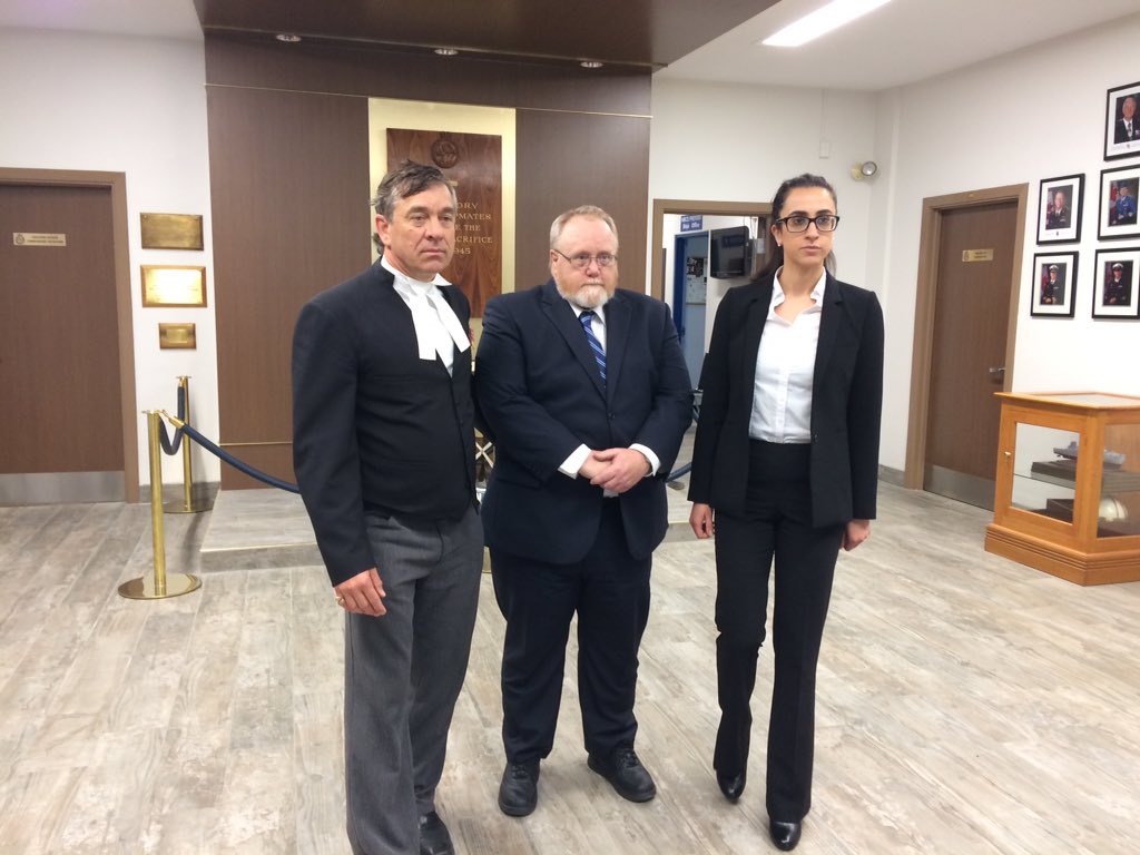 Former military medic James Wilks stands with his defence counsel at HMCS Prevost, London, on May 25, 2017.