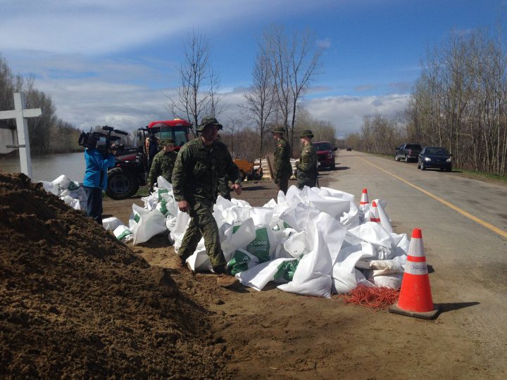 Soldiers with the Canadian Armed Forces fill sandbags in Yamachiche, Que., in order to reinforce temporary dikes on Tuesday, May 9, 2017. A state of emergency was declared in Yamachiche on Wednesday, May 10, 2017.