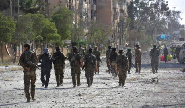 Fighters from the Kurdish-led Syria Democratic Forces, patrolling on a street in Tabqa, northern Syria. 