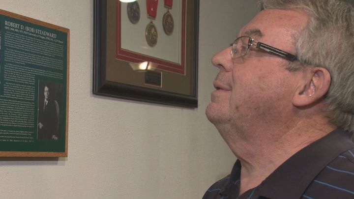 Bob Steadward looks at a wall showing some of the awards he\’s received.