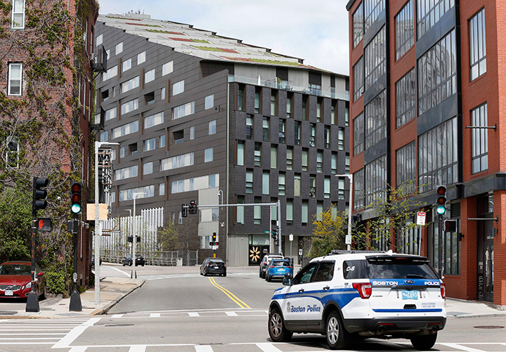 A Boston police vehicle patrols, Monday, May 8, 2017, near the scene of a double murder in the penthouse of the Macallen Building. 