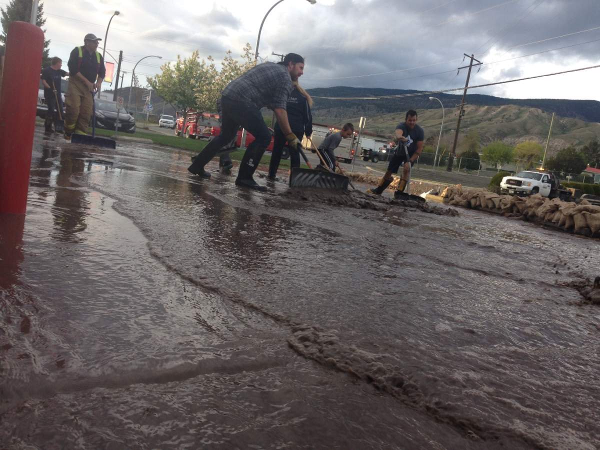 Firefighters try to stem the flow of water at the Cache Creek Fire Hall on May 5, 2017.