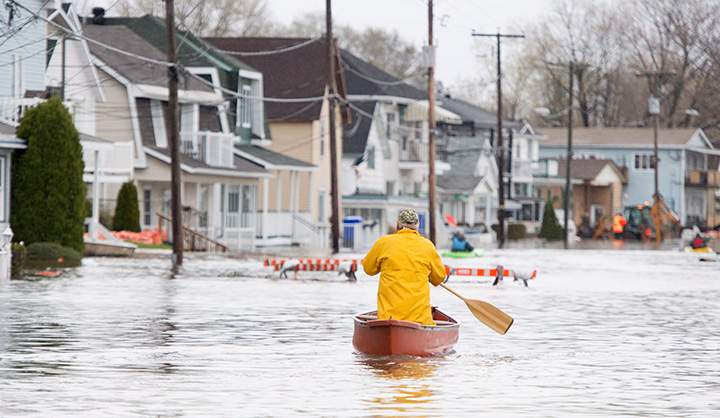 A man paddles his canoe past flooded homes in Gatineau, Que. Sunday May 7, 2017.