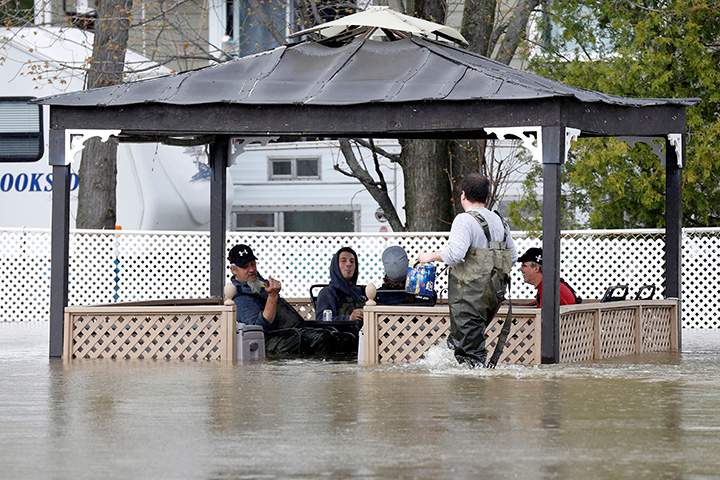 Residents drink beer while sitting in a flooded gazebo in Rigaud, Quebec, May 6, 2017.