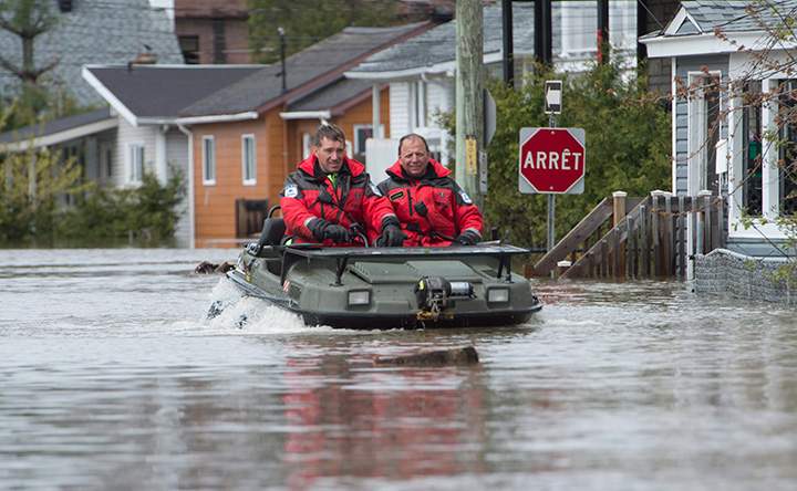 Police officers patrol streets in a flooded area of Gatineau, Que. Sunday May 7, 2017.