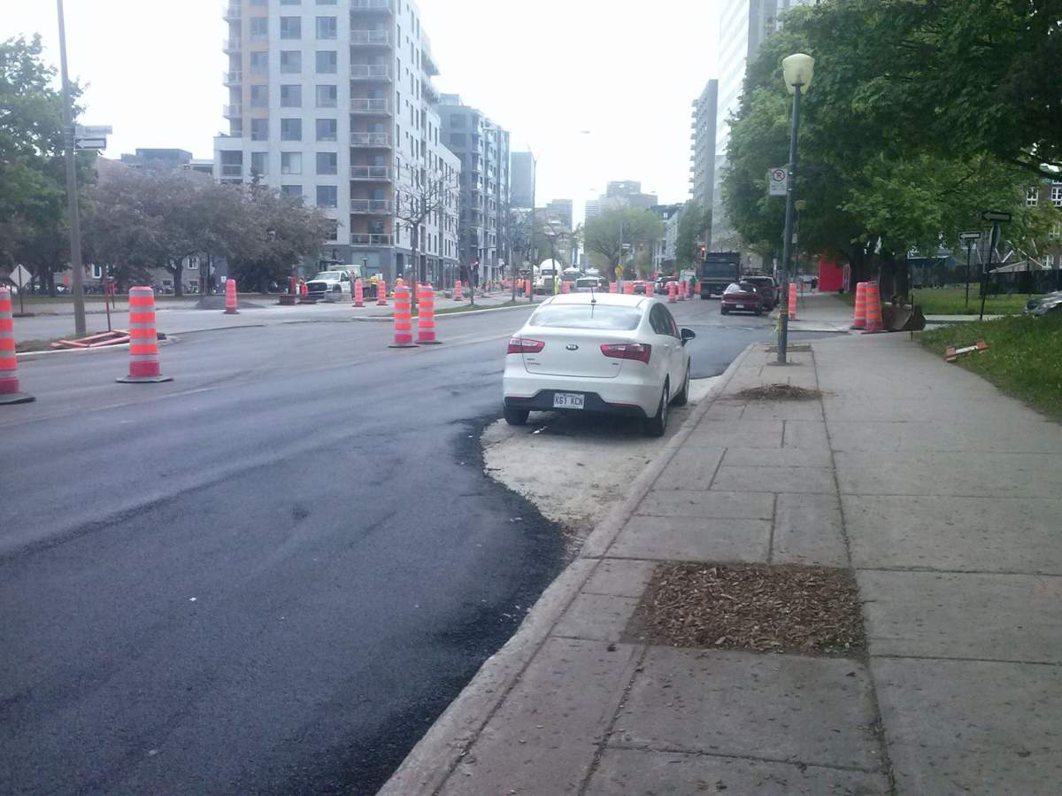 Paving on René Lévesque Boulevard took a little detour around a car, Friday, May 26, 2017.