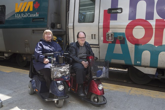 Martin Anderson and Marie Murphy are pictured in front of a Via Rail train at Toronto's Union Station on Saturday May 13, 2017. A deadline is looming for Via Rail to change its policies and allow more than one person travelling in a wheelchair at a time on its trains, or prove that doing so would be far too difficult. THE CANADIAN PRESS/Chris Young.