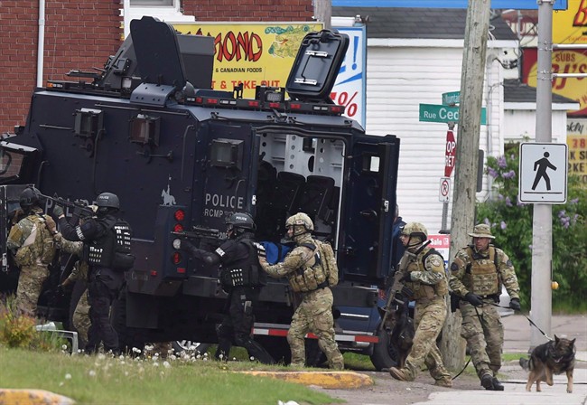 Emergency response officers enter a residence in Moncton, N.B. on Thursday, June 5, 2014. Mounties are reliving Justin Bourque's murder spree at an RCMP trial. It's alleged the RCMP failed to provide members and supervisors with the appropriate information, instruction and training in an active-shooter event, and didn't give members the appropriate equipment.