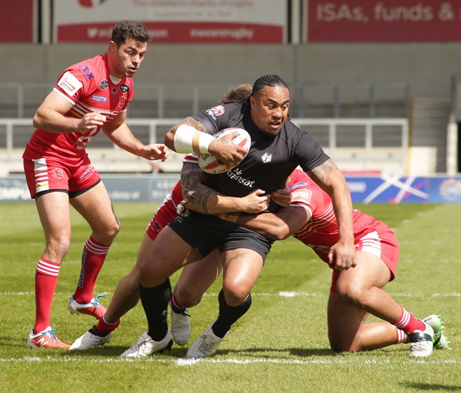 Toronto Wolfpack forward Fuifui Moimoi tries to break through a pair of tacklers in Toronto's 29-22 loss to the Salford Red Devils on April 23, 2017 in Salford, England, in the fifth round of the Ladbrokes Challenge Cup. THE CANADIAN PRESS/Toronto Wolfpack MANDATORY CREDIT.