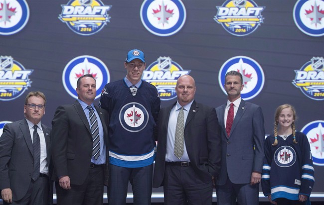 Logan Stanley stands on stage with members of the Winnipeg Jets management team at the NHL draft in Buffalo, N.Y., on Friday June 24, 2016.