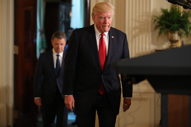 President Donald Trump, followed by Colombian President Juan Manuel Santos arrives for their joint news conference in the East Room of the White House in Washington, Thursday, May, 18, 2017. 