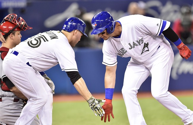 Toronto Blue Jays shortstop Troy Tulowitzki, right, celebrates with catcher Russell Martin after hitting a grand slam against the Cincinnati Reds on Monday.