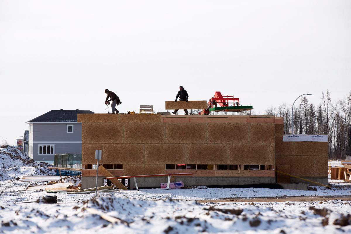 Builders work on a new home in the Beacon Hills area after wildfires last year destroyed most of the neighbourhood in Fort McMurray, Alta. Friday, April 21, 2017.
