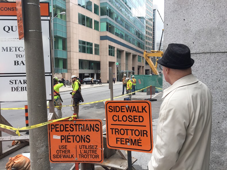 A man observes construction workers near the site of a gas leak in downtown Ottawa on Tuesday, May 2, 2017.