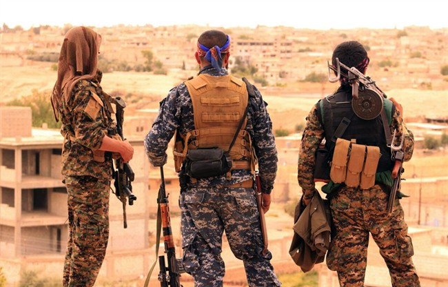 This Sunday, April 30, 2017, file photo, provided by the Syrian Democratic Forces (SDF), shows fighters from the SDF looking toward the northern town of Tabqa, Syria. 