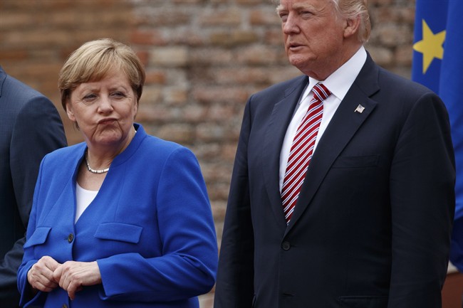 German Chancellor Angela Merkel and President Donald Trump pose for a family photo with G7 leaders at the Ancient Greek Theater of Taormina, Friday, May 26, 2017, in Taormina, Italy. 