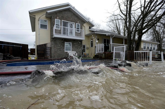 Rising water from the Ottawa River is nearly level with the deck and swimming pool at a home in Rockland, Ont., about 40 kilometres east of Ottawa, on Sunday, May 7, 2017.