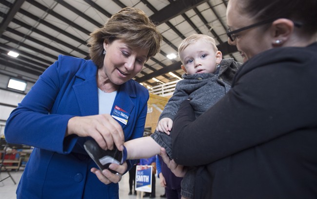 B.C. Liberal leader Christy Clark puts a shoe on a little boy as she makes a campaign stop in Campbell River, B.C., Friday, May 5, 2017. 