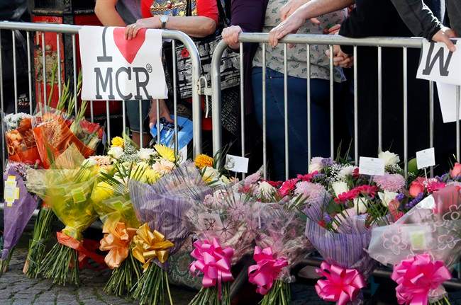 People attend a vigil in Albert Square in Manchester, England, the day after an attack at an Ariana Grande concert.