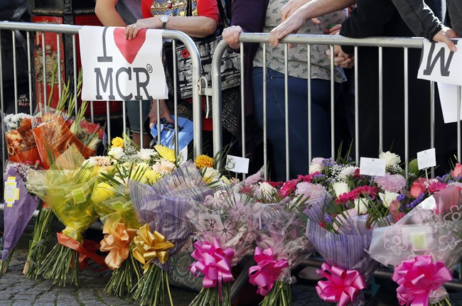 People attend a vigil in Albert Square in Manchester, England, the day after an attack at an Ariana Grande concert.