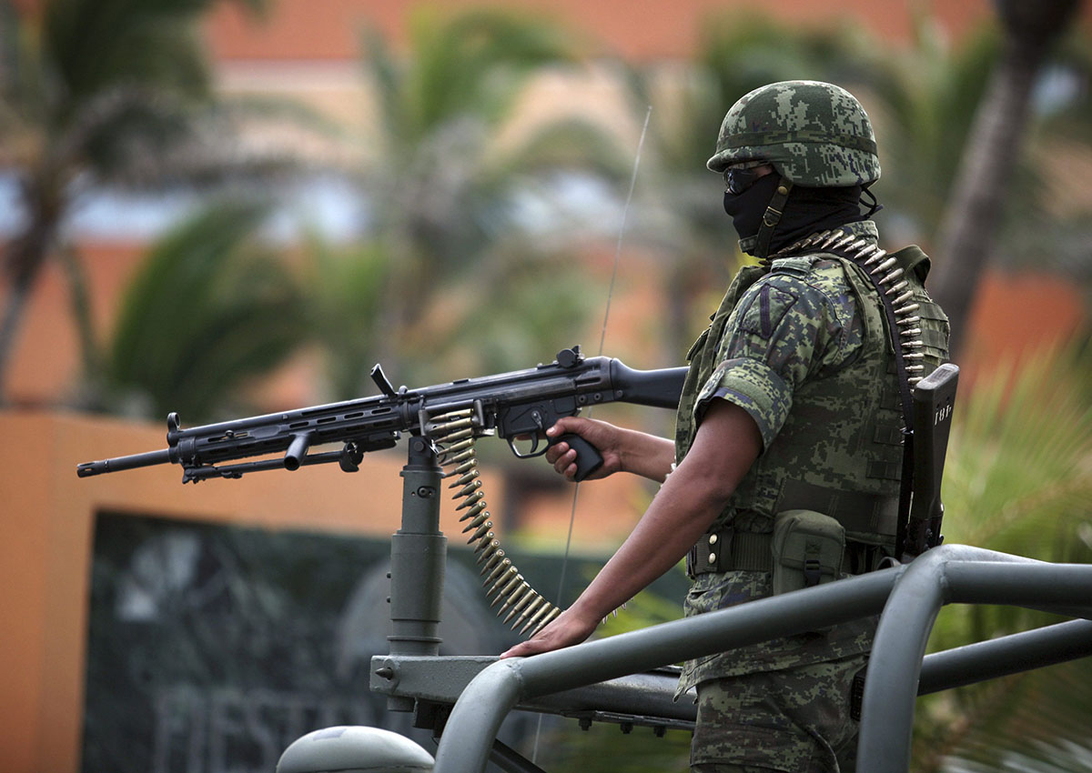 FILE PHOTO: A Mexican army soldier mans a gun on top of a vehicle while guarding the perimeter around the site of a state prosecutors convention in the Gulf port city of Veracruz, Mexico, Thursday Sept. 22, 2011.