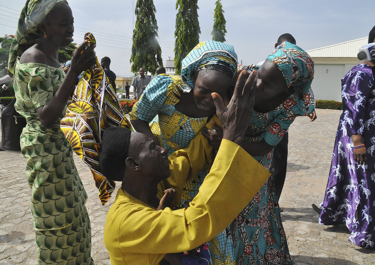 Family members celebrate as they embrace a relative, one of the released kidnapped schoolgirls, in Abuja, Nigeria, Saturday, May 20, 2017. 
