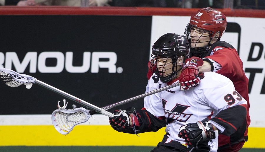 Calgary Roughnecks' Curtis Manning, right, wraps his stick around Vancouver Stealth's Johnny Powless during NLL lacrosse action in Calgary, Alberta on Saturday, Feb. 21, 2015.