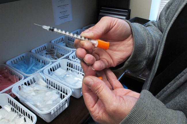 FILE - In this March 24, 2016 photo, a nurse for eastern Indiana's Fayette County holds one of the syringes provided to intravenous drug users taking part in the county's state-approved needle exchange program at the county courthouse in Connersville, Ind.