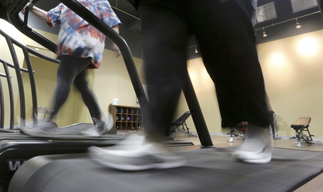 FILE - In this Thursday, Jan. 3, 2013 file photo, gym members use a treadmill to warm up for a morning exercise class in Addison, Texas. 
