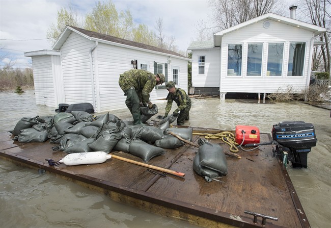 Soldiers build a dam with sandbags around a flooded house on the shores of Lake St-Pierre in Yamachiche, Que. on Thursday, May 11, 2017. The annual costs for natural disaster response in Canada is climbing.